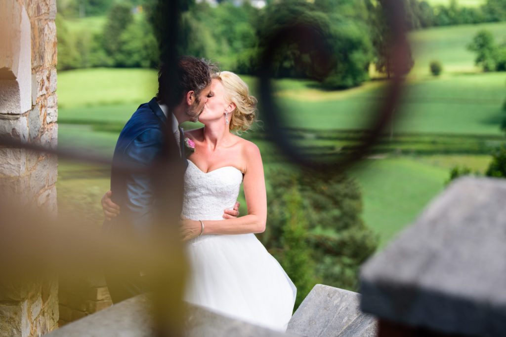 Documentaire trouwfotografie van een intiem moment tussen de tralies van een kasteel in België