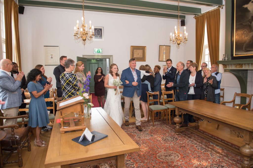 Huwelijksfotograaf vangt emotionele momenten in de trouwzaal.